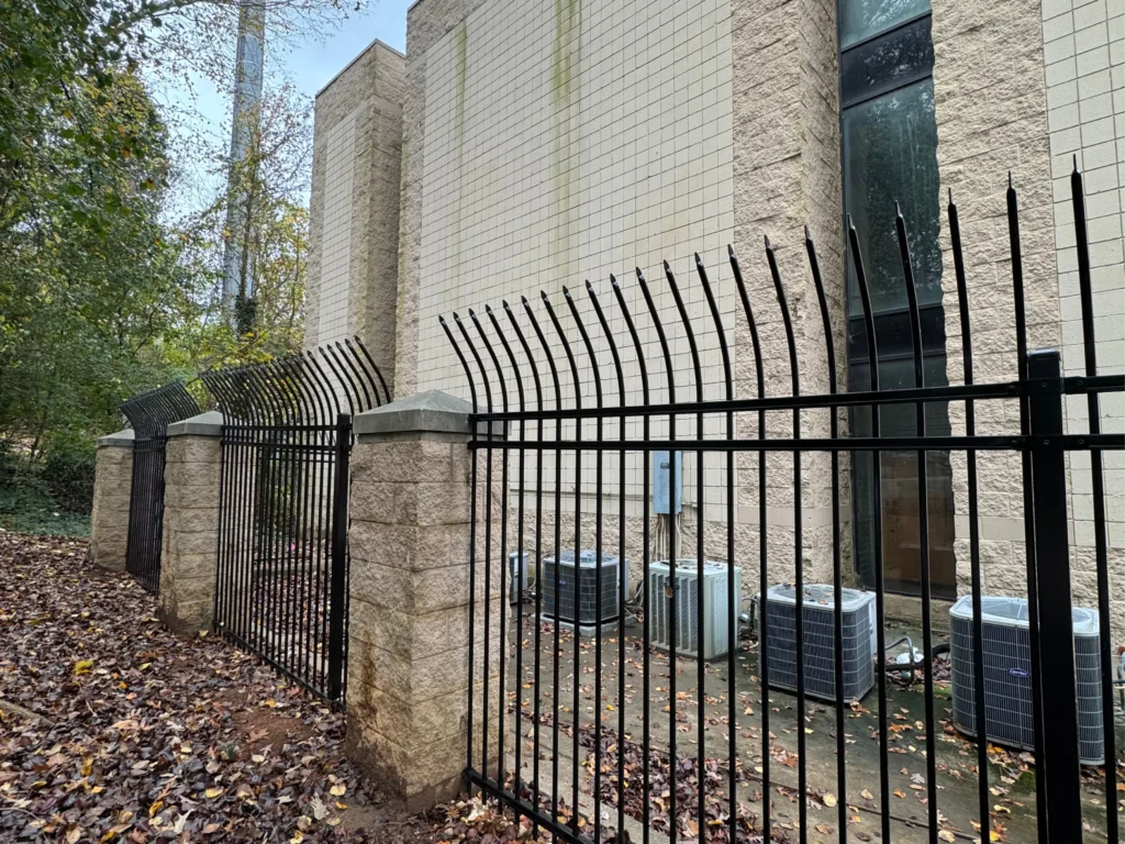 Commercial Fence in Peachtree Corners - GA being installed beside a warehouse drive with sliding gate access